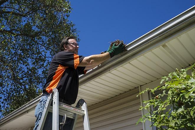 repairman using a ladder to access a damaged gutter for repair in Allentown